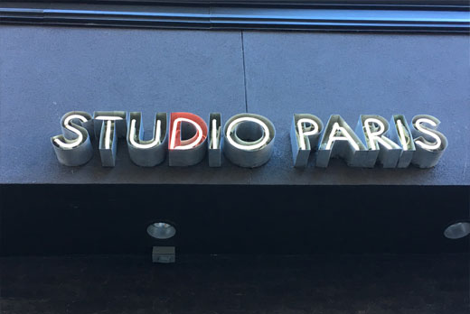 Neon sign featuring studio paris glow lettering