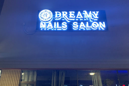Neon sign reading 'dreamy nails shopfront' in modern style