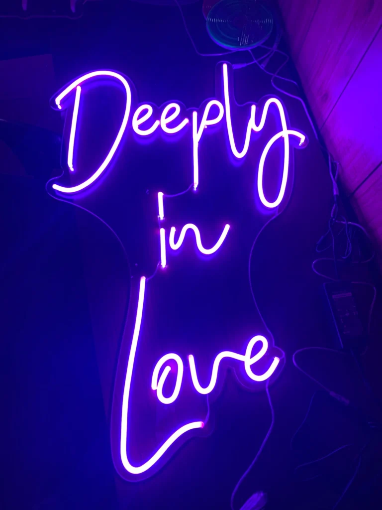 Neon sign reading 'deeply in love purple script' in modern style