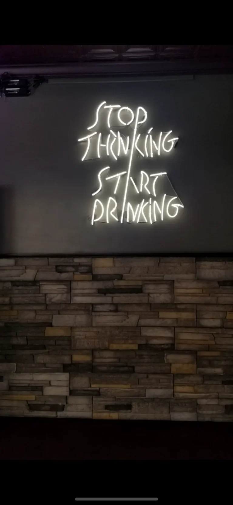 Neon sign featuring stop thinking bar signage